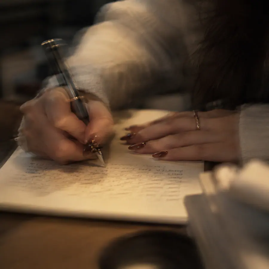 Person writing financial goals in a notebook